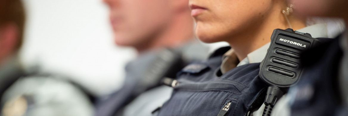 Une agente de la GRC en uniforme, assise dans une rangée de policiers.