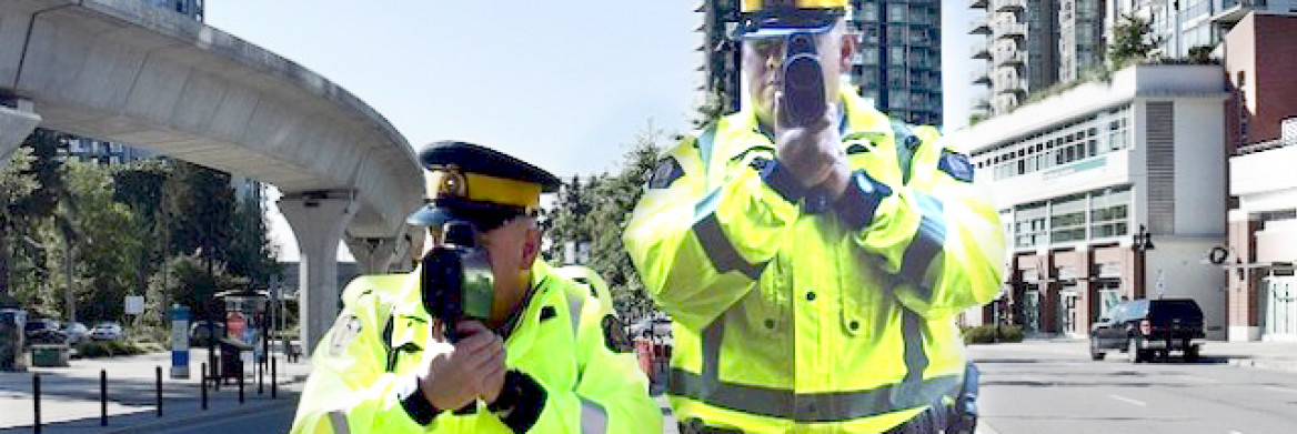 A cut-out of an RCMP officer and a real male RCMP officer point their laser detectors forward at chest level.