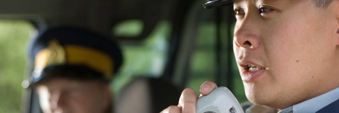 Police officer in car talking on radio.