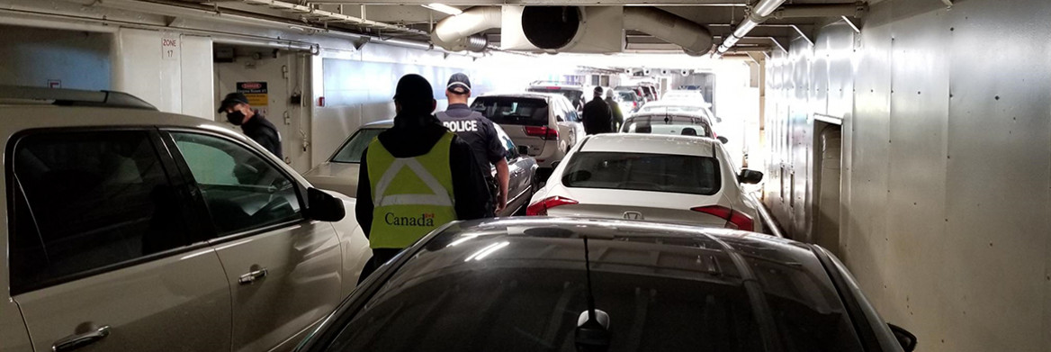 Des policiers et d'autres agents circulent entre des véhicules sur un pont fermé.