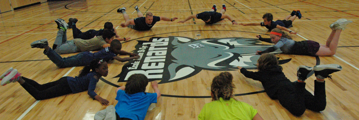 Young people and instructors exercise in a gym.