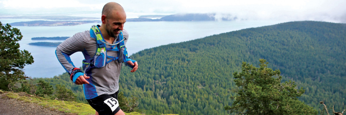 Homme qui court dans une piste en montagne.