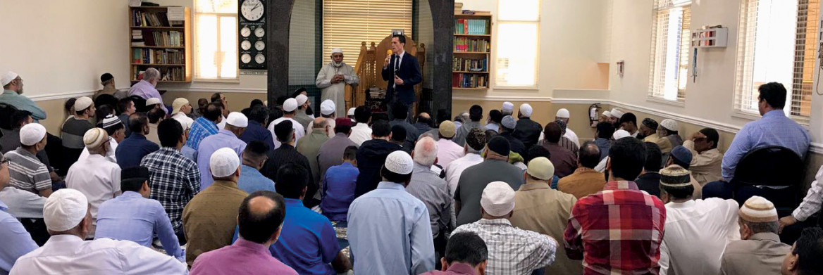 A man addresses worshippers at a mosque.