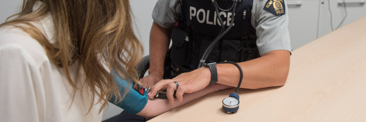 Police officer tests woman's blood pressure.