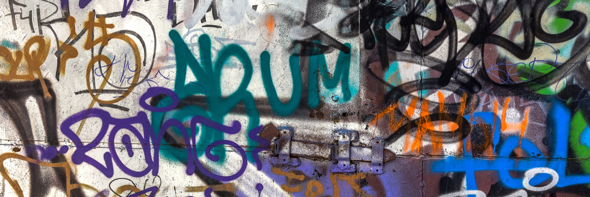 Multi-coloured graffiti is on a metal door. 