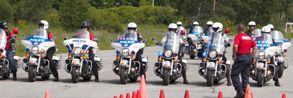 Des hommes sur leur motocyclette forment une ligne.