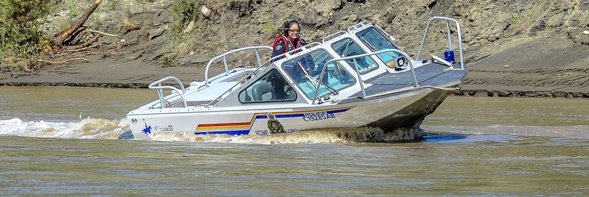 Female police officer operating a motor boat.