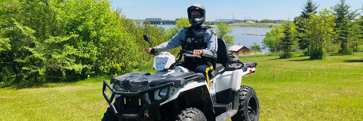 An RCMP officer sits on an All-terrain Vehicle (ATV). 