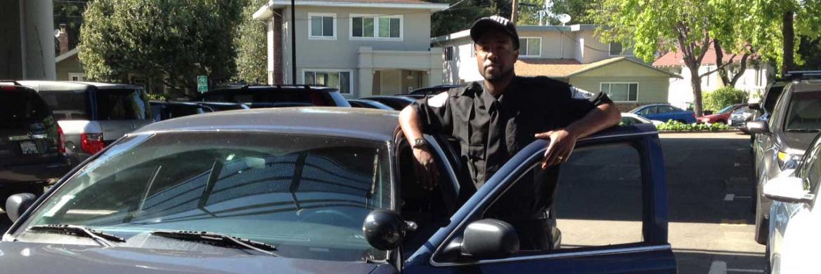 Man standing outside door of car.