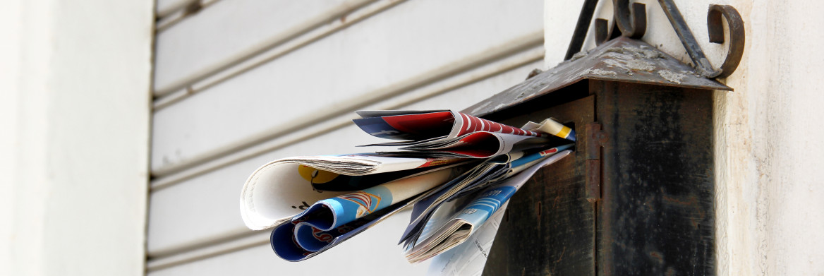 Une boîte aux lettres rouillée pleine à craquer.