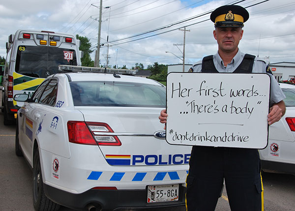 Cst. Douglas Baker holding a whiteboard: “Her first words… ‘There’s a dead body’,”